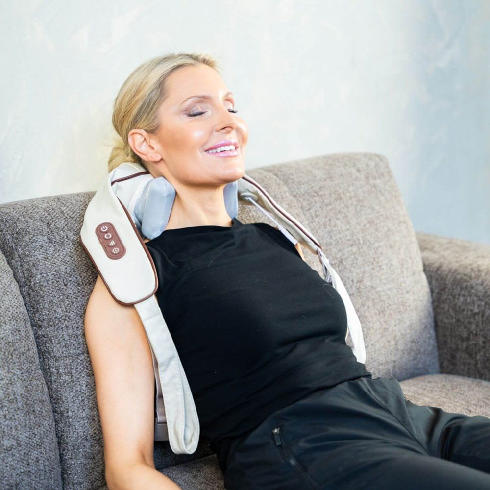 En kvinne i sofaen med NeckCare over skuldrene